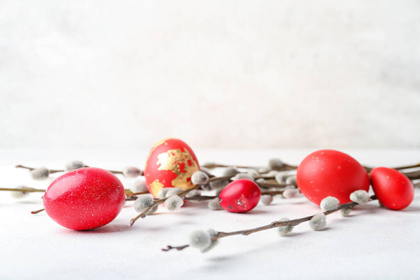 Painted Easter eggs and pussy willow branches on light background - Foto, imagen