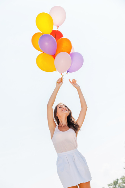 Beautiful woman holding colorful balloons - Foto, Imagen
