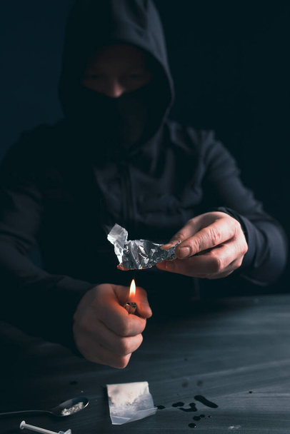 Addict/junkie man preparing drugs. The concept of crime and drug addiction. - Zdjęcie, obraz