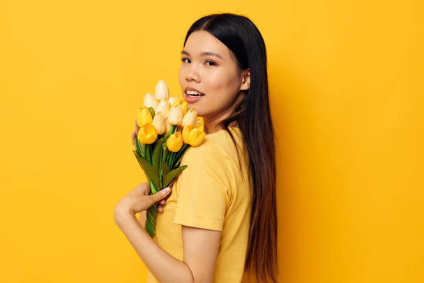 woman with Asian appearance with a bouquet of yellow flowers romance studio model unaltered - Фото, изображение