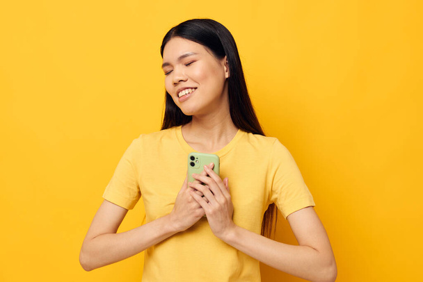 Portrait Asian beautiful young woman phone communication fun use yellow background unaltered - Photo, image