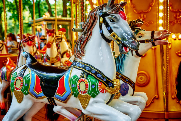 Carousel with colorful horses at amusement park, Merry go round with horse, Vintage ride attraction for children - Photo, Image