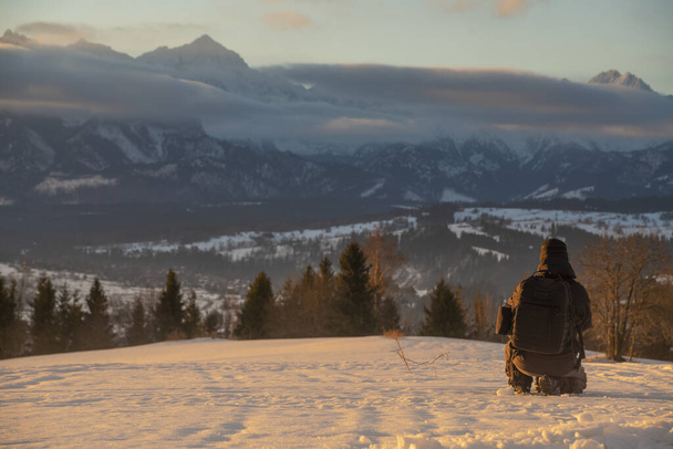 Photographer taking pictures of mountain landscape in winter - Φωτογραφία, εικόνα