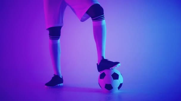 Stüdyoda, bir futbol oyuncusunun ayağının altındaki futbol topunu yavaş çekimde yaklaş. Stüdyoda topu olan profesyonel bir futbolcu. - Video, Çekim