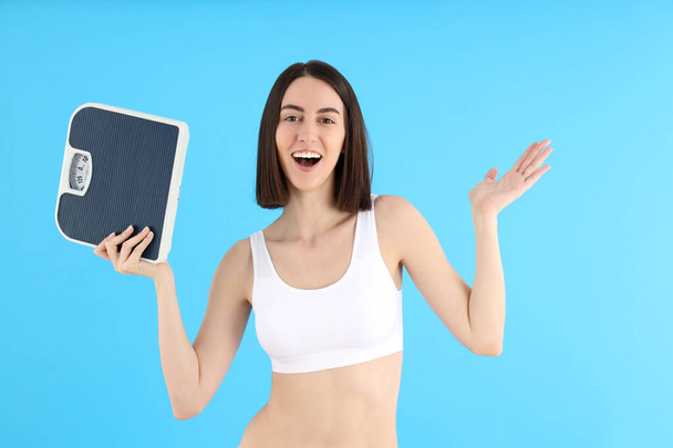Concept of weight loss with young slim woman on blue background - Fotó, kép