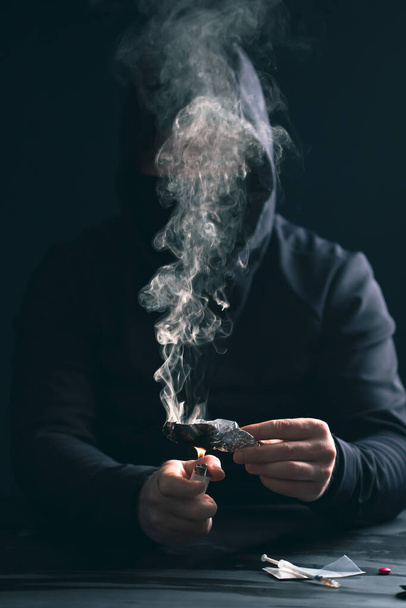 Addict/junkie man preparing drugs. The concept of crime and drug addiction. - Φωτογραφία, εικόνα