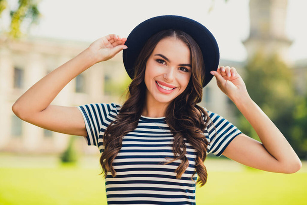 Photo of pretty cute young woman dressed striped dress arms cap walking smiling outside beautiful landscape - Zdjęcie, obraz