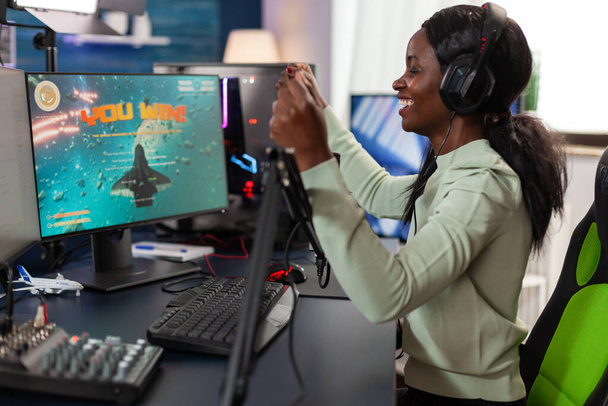 Onnellinen afrikkalainen amerikkalainen nainen gamer yllään kuulokkeet - Valokuva, kuva