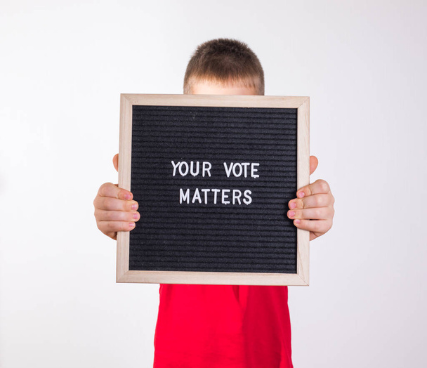 子供男の子保持文字ボードでテキストあなたの投票白の背景に関する事項 - 写真・画像