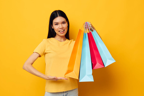 Portrait Asian beautiful young woman with packages in hands shopping studio model unaltered - Foto, imagen