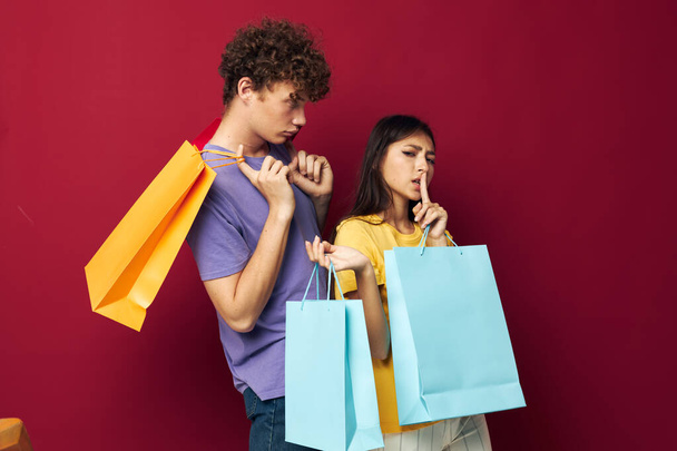 portrait of a man and a woman colorful bags shopping fun isolated background unaltered - Zdjęcie, obraz