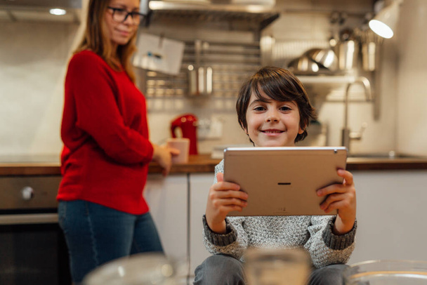 little boy using digital tablet in kitchen - Photo, Image