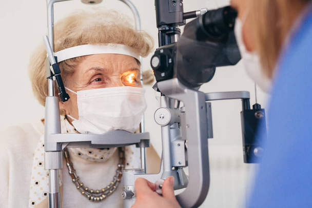 older woman has eye examination. - Фото, изображение