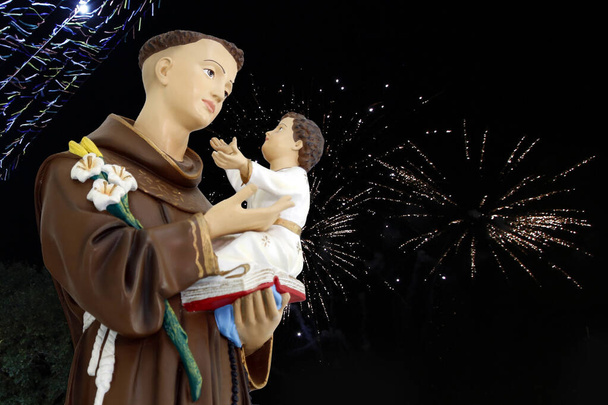 Sant'Antonio di Lisbona o Sant'Antonio de Padova e il bambino Gesù immagine cattolica con bandiere colorate di giugno e fuochi d'artificio - Foto, immagini