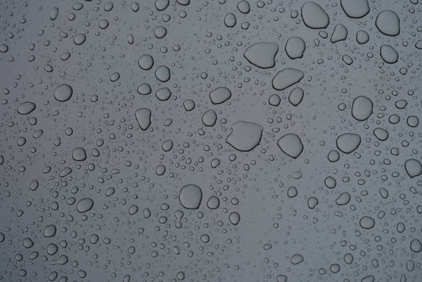 Esőcseppek sötét üveg esős napon közelkép háttér - Fotó, kép
