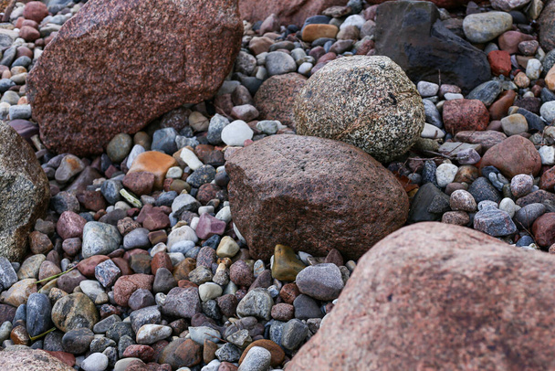 Zamknij widok fotografii z małych i dużych skał na plaży. Zdjęcie zrobione w pochmurny jesienny dzień. - Zdjęcie, obraz