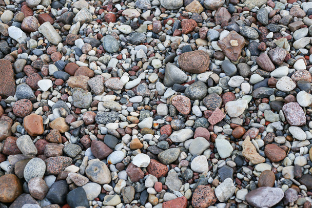 Nahaufnahme der Fotografie mit kleinen und großen Felsen an einem Strand. Foto aufgenommen an einem bewölkten Herbsttag. - Foto, Bild