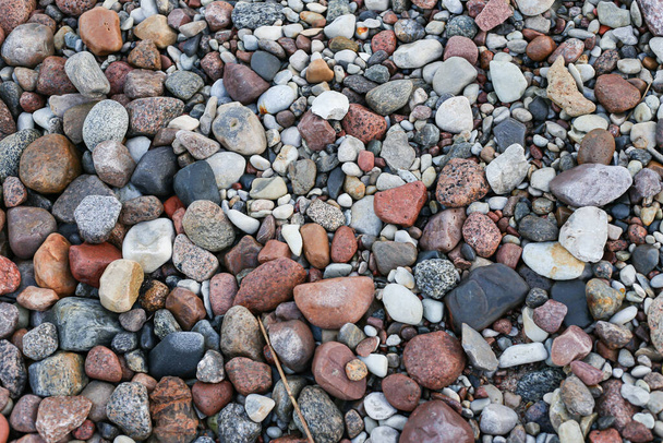 Zblízka fotografie pohled s malými a velkými kameny na pláži. Fotografie pořízená v zatažený podzimní den. - Fotografie, Obrázek