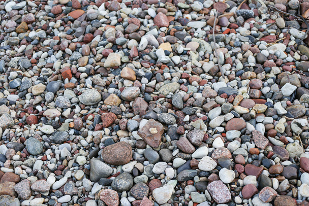 Nahaufnahme der Fotografie mit kleinen und großen Felsen an einem Strand. Foto aufgenommen an einem bewölkten Herbsttag. - Foto, Bild