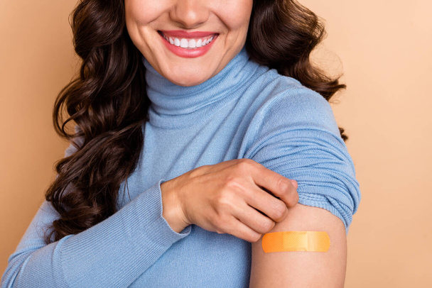 Photo of confident positive woman wear blue sweater showing shoulder sticky plaster isolated beige color background - Φωτογραφία, εικόνα