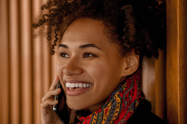 Una chica de piel oscura con un teléfono - Foto, imagen