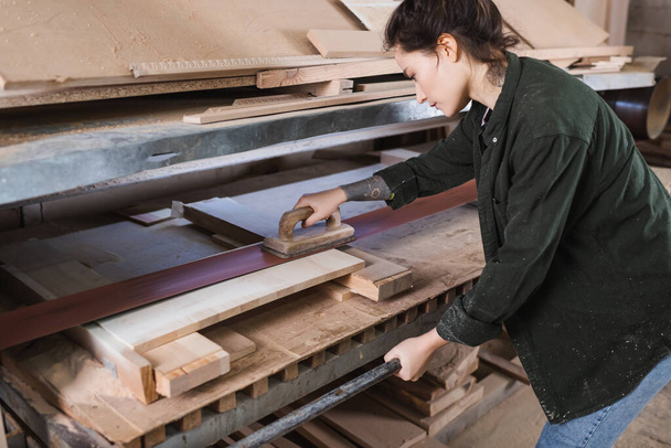Dövmeli marangozun atölyedeki talaş parlatma tahtasında yan görünüşü  - Fotoğraf, Görsel