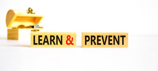 Learn and prevent symbol. Concept words Learn and prevent on wooden blocks on beautiful white background. Wooden chest with coins. Business learning and learn and prevent concept, copy space. - Photo, Image