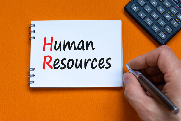 HR Human resources symbol. Concept words HR Human resources on white note. Businessman hand, calculator. Beautiful orange background. Business and HR human resources concept. - Fotografie, Obrázek