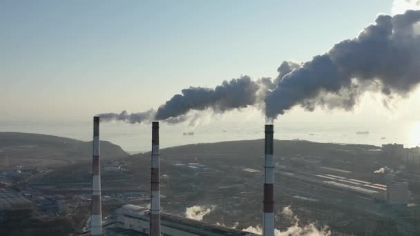 Een werkende fabriek met schoorstenen vol rook. - Video