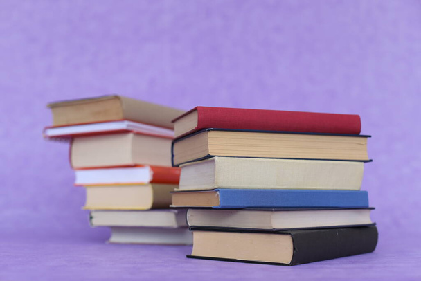 Montón de libros sobre fondo violeta
 - Foto, Imagen