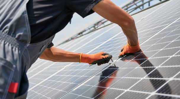 Mãos de trabalhador masculino instalando painéis solares ao ar livre. - Foto, Imagem