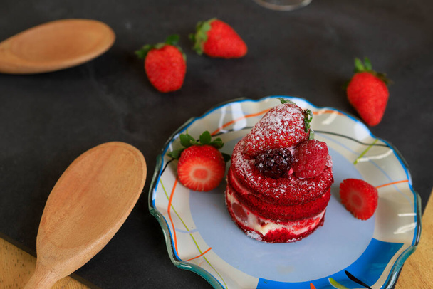 Gâteau aux fraises, rempli de crème, sur une assiette colorée décorée de fruits
 - Photo, image