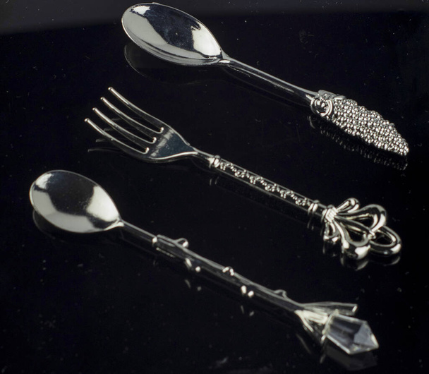 Bestek gezet met vorkmes en lepel geïsoleerd op zwart - Foto, afbeelding