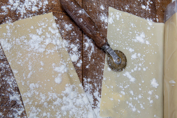 Pastel frito, ou pastelaria em Inglês, massa e pastel cru, sobre mesa de madeira rústica, com cortador de massa. São Paulo, Brasil - Foto, Imagem