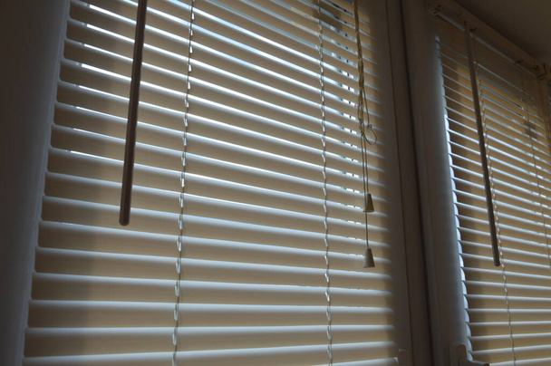 Horizontal blinds shine sunlight into a the room - Photo, Image
