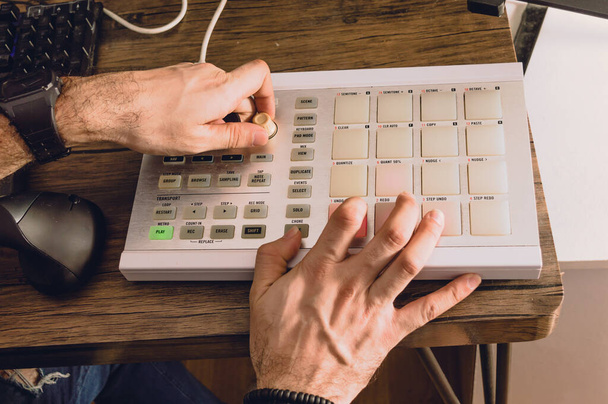 kaukázusi férfi kezek zenélni egy midi vezérlő egy otthoni stúdióban, az ember, hogy beat és kereskedelmi elektronikus zene, zeneipar koncepció. - Fotó, kép