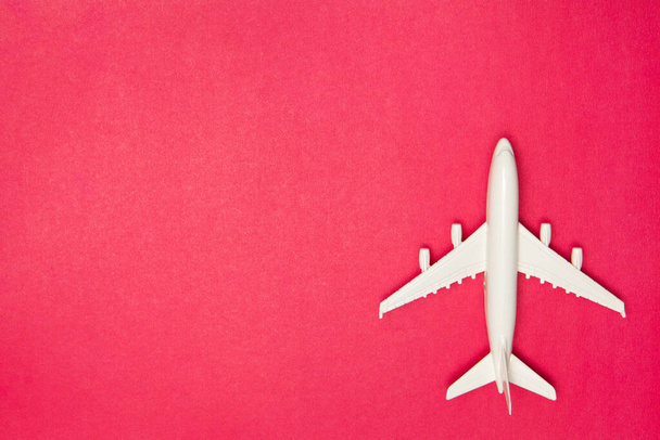 Airplane model. White plane on pink background. Travel vacation concept. Summer background. Flat lay, top view, copy space. - Photo, image