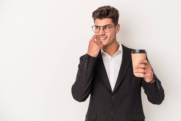 Młody biznes biały mężczyzna trzyma zabrać kawę na białym tle zrelaksowany myśląc o czymś patrząc na przestrzeń kopii. - Zdjęcie, obraz
