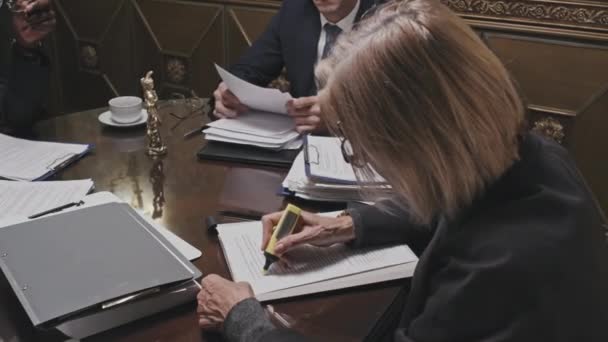 Γυναίκα δικηγόρος κάθεται στο τραπέζι του γραφείου, ανάγνωση του εγγράφου και σήμανση κειμένου με στυλό highlighter - Πλάνα, βίντεο