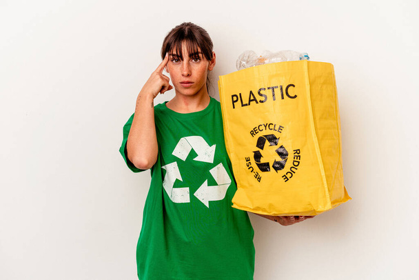 Junge Argentinierin recyceltes Plastik isoliert auf weißem Hintergrund zeigt mit dem Finger auf die Schläfe, denkt nach, konzentriert sich auf eine Aufgabe. - Foto, Bild
