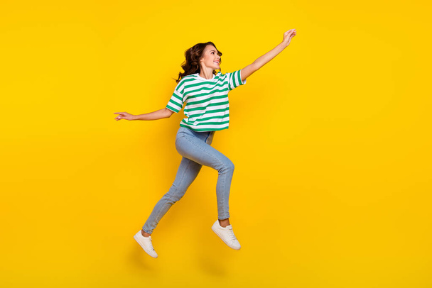 Full size profile side photo of youth lady run walk try to catch look empty space isolated over yellow color background. - Foto, immagini