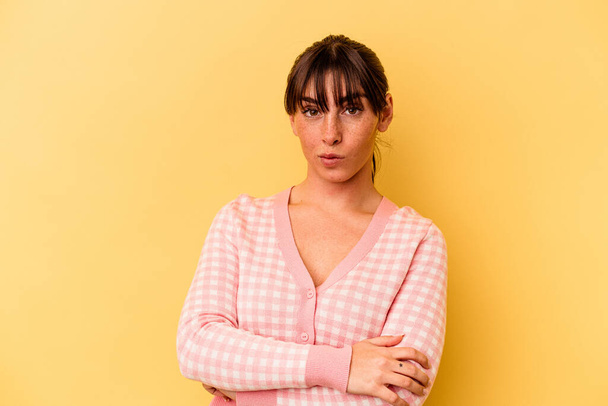 Young Argentinian woman isolated on yellow background suspicious, uncertain, examining you. - Photo, Image