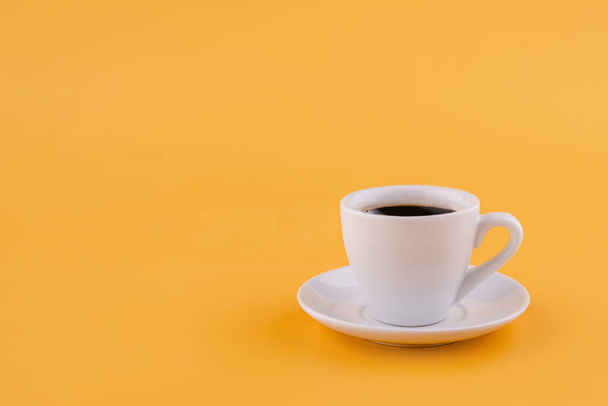 cup of americano coffee on a yellow background. Space for text. - Photo, Image
