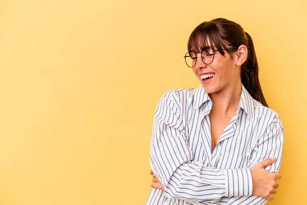 Young Argentinian woman isolated on yellow background smiling confident with crossed arms. - 写真・画像
