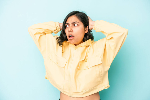 Young latin woman isolated on blue background screaming, very excited, passionate, satisfied with something. - Photo, Image
