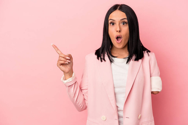 Young caucasian woman with one arm isolated on pink background pointing to the side - Photo, Image