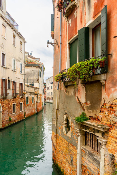 2021年12月2日-イタリア、ヴェネツィア:建物の間を流れる狭い運河の眺め. - 写真・画像