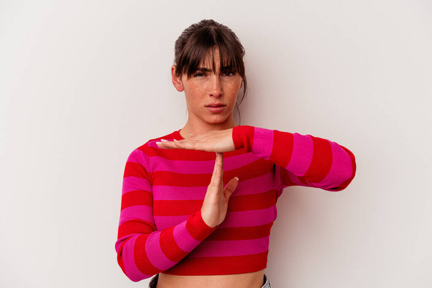 Young Argentinian woman isolated on white background showing a timeout gesture. - Фото, изображение