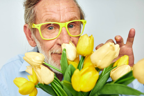 Portrait elderly man yellow bouquet of flowers posing isolated background - Valokuva, kuva