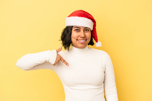 若いですラテン女性祝うクリスマス孤立した上の黄色の背景人指摘によって手にシャツコピースペース,誇りと自信 - 写真・画像